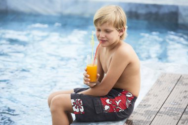 Otel Yüzme Havuzu tarafından dinlenme ne zaman meyve kokteyl yudumlarken çocuk