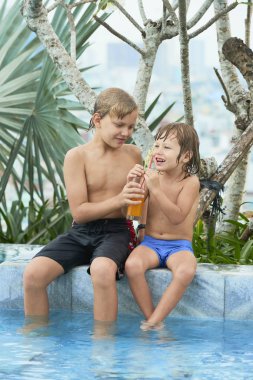 Neşeli varoluş çocuk bardak taze meyve suyu ile küçük kardeşim paylaşım