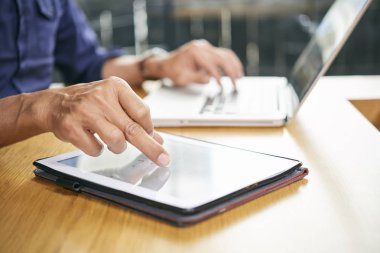 Ofiste çalışırken tablet bilgisayarda uygulama kullanarak iş adamı