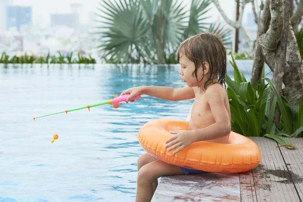 Menino Bonito Sentado Borda Piscina Anel Inflável Pesca Com Haste — Fotografia de Stock