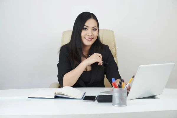 オフィスで彼女の机でプロジェクトに取り組んで美しい笑みを浮かべてベトナム人実業家 — ストック写真