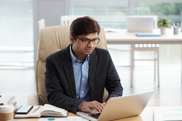 Indyjski Biznesmen Okulary Czytanie Artykułu Ekranie Laptopa — Zdjęcie stockowe