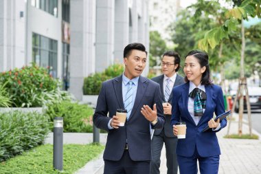 Neşeli Asyalı kadın ve erkek arkadaşı ile sokakta yürürken kahve ile