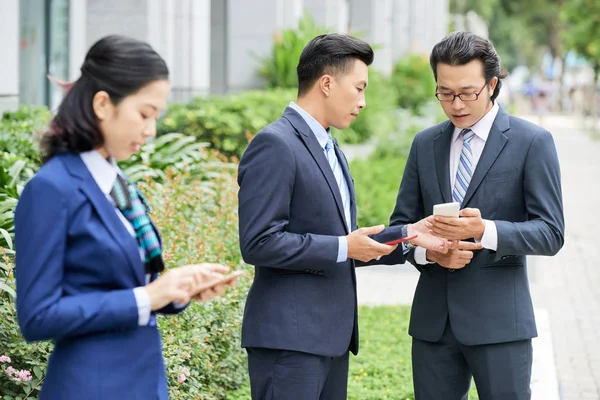 Jóvenes Empresarios Asiáticos Con Teléfonos Inteligentes Pie Calle Hablando Con — Foto de Stock