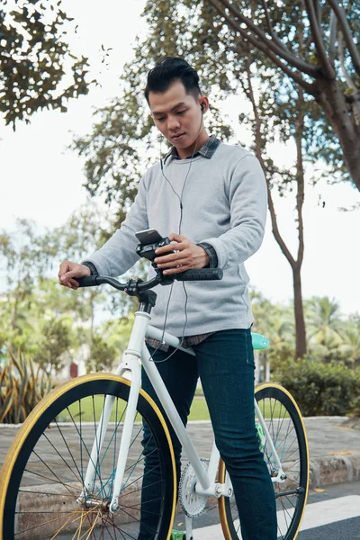 Снизу Снимок Молодого Азиата Слушающего Музыку Просматривающего Смартфон Велосипедном Руле — стоковое фото