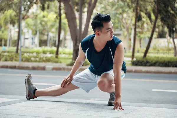 Bonito Asiático Cara Realizando Exercício Perna Olhando Para Fora Enquanto — Fotografia de Stock