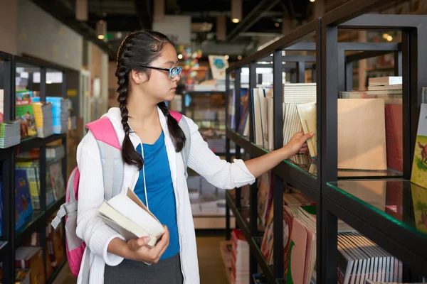 Tonårsflicka Med Ryggsäck Promenader Bland Bokhyllor Skolans Bibliotek Och Välja — Stockfoto