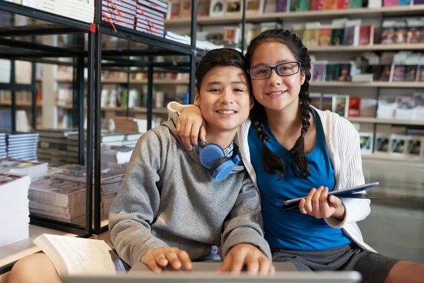 Contenido Chica Niño Abrazando Sosteniendo Gadgets Mientras Mira Cámara Biblioteca —  Fotos de Stock