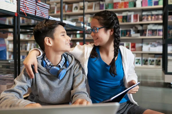 Fröhliche Teenager Jungen Und Mädchen Mit Gadgets Der Schulbibliothek Umarmen — Stockfoto