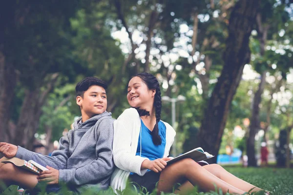 아시아 소년과 학교에 잔디에 앉아서 머리를 — 스톡 사진
