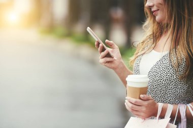 Sütlü kahve içme ve metin okuma gülümseyen kadın onun Smartphone'da mesajla