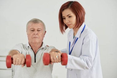 Dayanıklılık geliştirmek için yaşlı adam dumbbells ile egzersiz yaparak