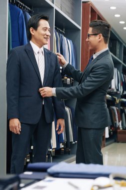 Mutlu Vietnamlı butik onun yeni ısmarlama takım elbise üzerinde çalışıyor