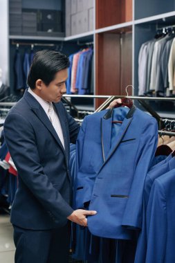 Orta yaşlı Vietnamlı takım elbise moda butik seçme