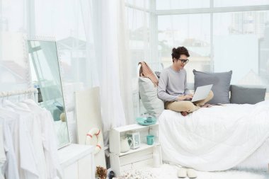 Onun ışık Oda oturan ve e-postaları cevap Vietnamlı gülümseyen