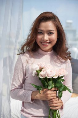 Taze çiçekler buket tutan çekici genç Asyalı kadın