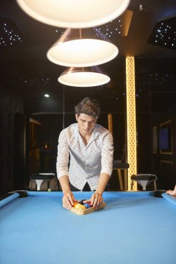 Genç adam Top Bilardo masası üzerinde bir araya ve gece kulübünde Bilardo oynamak için gidiyor