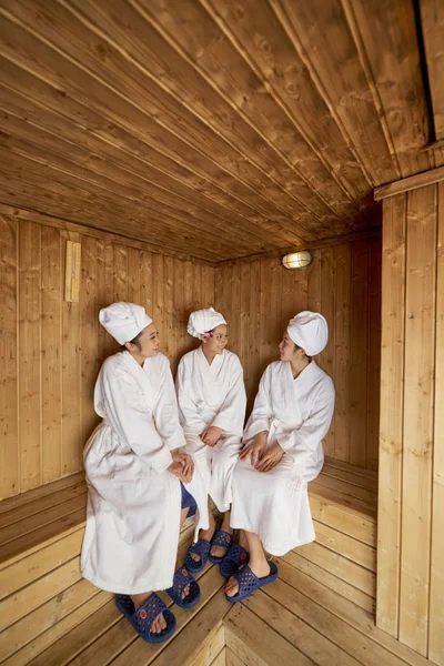 Grupo Jovens Amigas Vestindo Roupões Banho Relaxando Juntas Sala Sauna — Fotografia de Stock