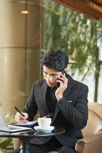 Elegantní Vietnamský Podnikatel Sedí Kavárně Mluví Telefonu Pořizování Poznámek Planner — Stock fotografie