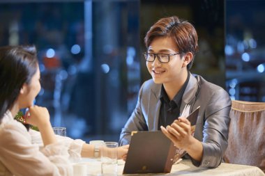 Restoran menüsünde Okuma ve gülümseyen genç mutlu Vietnamca Çift 