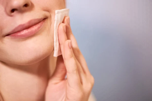 若い女性の健康的なきれいな肌にコットンで顔を洗浄のクローズ アップ — ストック写真