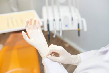 Doktor Diş Office yordamı önce beyaz lateks eldiven koyarak kırpma görüntüsünü