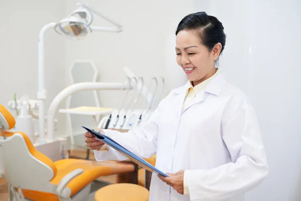 Mujer Asiática Adulta Consultorio Dental Sujetando Portapapeles Leyendo Papel Con —  Fotos de Stock