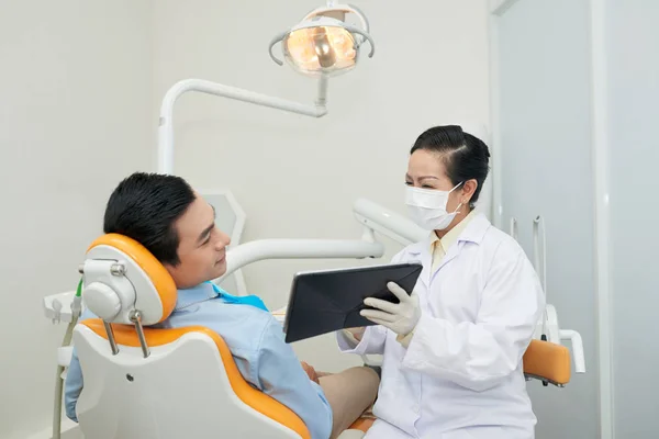 Врач Стоматолог Маске Показывает Таблетку Азиатскому Мужчине Стоматологическом Кресле Время — стоковое фото