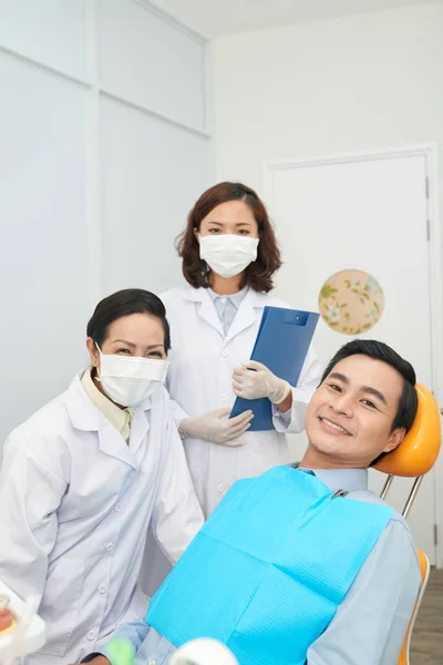 Donne Abiti Bianchi Medici Piedi Con Uomo Asiatico Sedia Dentale — Foto Stock