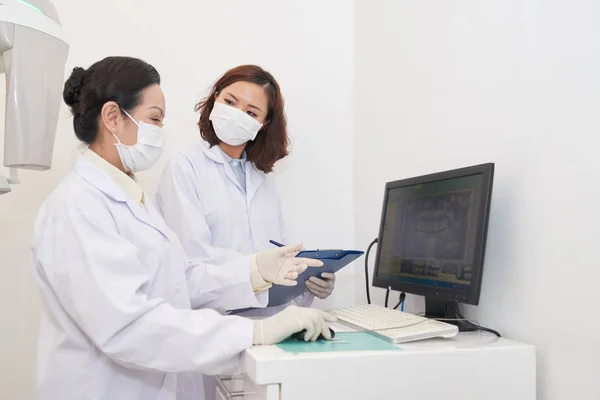牙科诊所中的亚洲专业妇女在办公室的电脑屏幕上讨论全景 — 图库照片