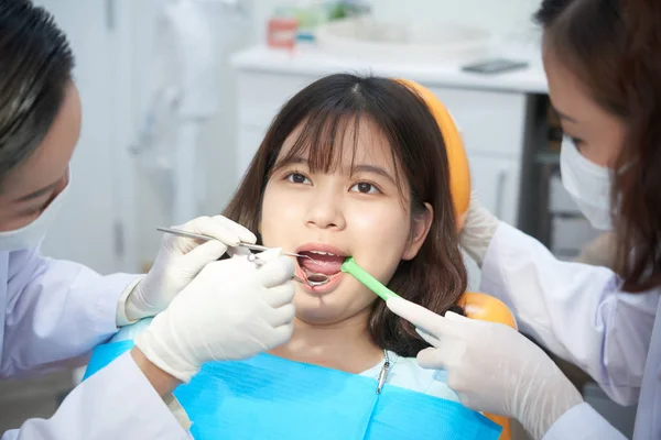 Profissionais Dentistas Examinando Cavidade Oral Jovem Asiática Cadeira Escritório Trabalhando — Fotografia de Stock