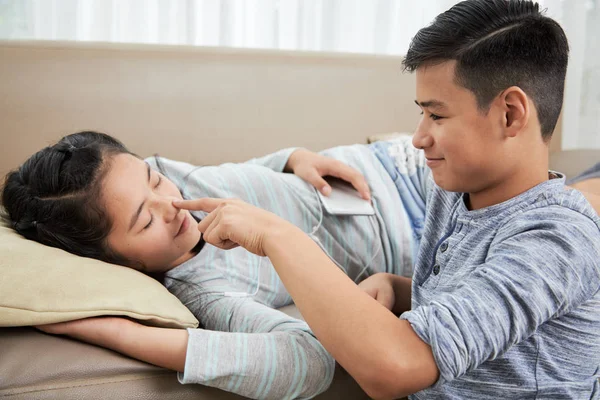 Vrolijke Tiener Wijzend Neus Van Zijn Slapende Tweelingzus — Stockfoto