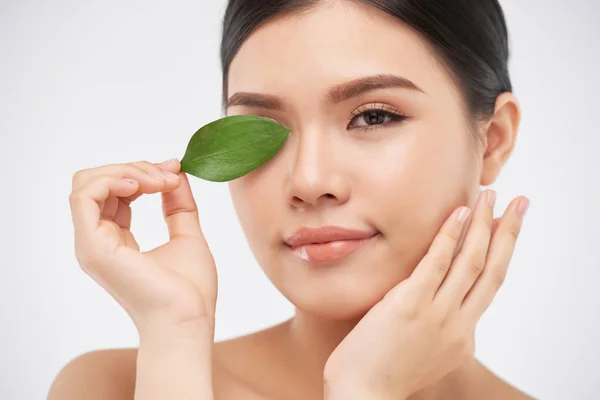 Lächelnd Hübsche Asiatische Frau Bedeckt Auge Mit Grünem Blatt — Stockfoto