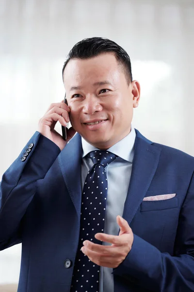Улыбающийся Вьетнамский Предприниматель Объясняет Деловому Партнеру Телефону — стоковое фото