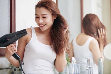 Genç Asyalı kadın saçını sabah üfleme