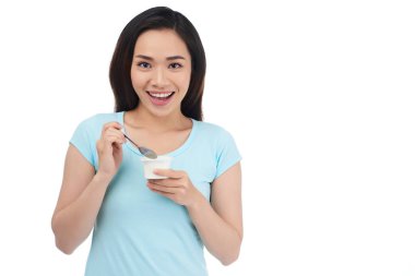 Çekici genç Vietnamlı kadın üzerinde beyaz izole yoğurt yeme