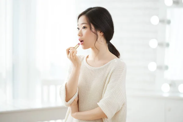 漂亮的年轻韩国妇女应用粉红色的口红 — 图库照片