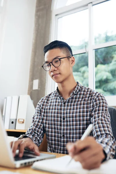Jovem Concentrado Ásia Homem Vestindo Verificado Camisa Óculos Sentado Mesa — Fotografia de Stock