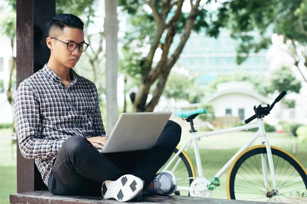 Pemuda Asia Terkonsentrasi Dalam Pakaian Santai Bekerja Pada Laptop Duduk — Stok Foto