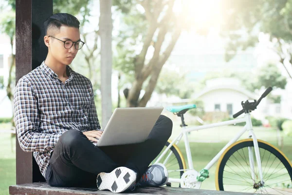 Jovem Homem Asiático Sério Roupas Casuais Usando Notebook Enquanto Sentado — Fotografia de Stock