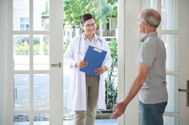 Açılış kapı gülümseyen doktor evde ziyaret yapmak için yaşlı adam