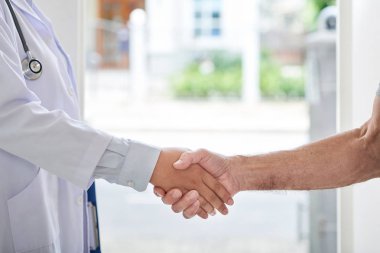 Komuta sizde ve ev ziyareti sırasında tokalaşırken üniformalı kadın doktor kırpma görüntüsünü