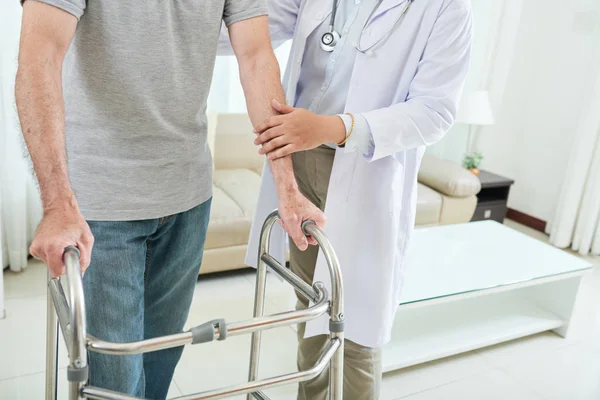 Doktor walker kullanarak yardımıyla kırpma yaşlı adam evde yürüyüş 