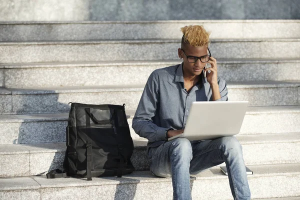 Elegante Joven Trabajando Ordenador Portátil Hablando Por Teléfono Cuando Sienta — Foto de Stock