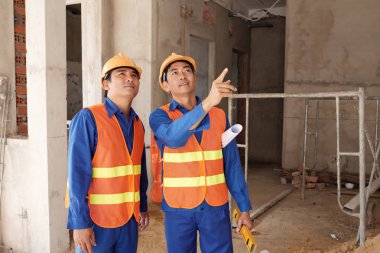 Konut yapı sürecinin yüklenici ile tartışırken Vietnamca inşaat işçisi 