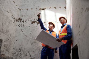 Vietnamca inşaat işçisi ile ev remodeling süreci tartışıyor blueprint