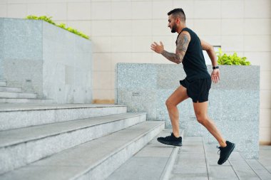 Siyah spor odaklı seyir Caddesi üzerinde açık havada dışarı çalışırken üst katta çalışan adam yan görünüm