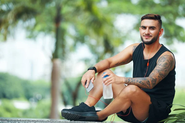 Bonito Homem Barbudo Com Fones Ouvido Telefone Sentado Chão Segurando — Fotografia de Stock