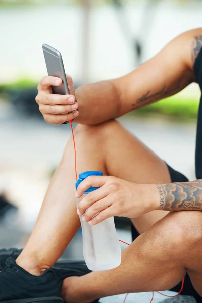 Tiro Sin Rostro Atleta Tatuado Sosteniendo Botella Agua Utilizando Teléfono —  Fotos de Stock