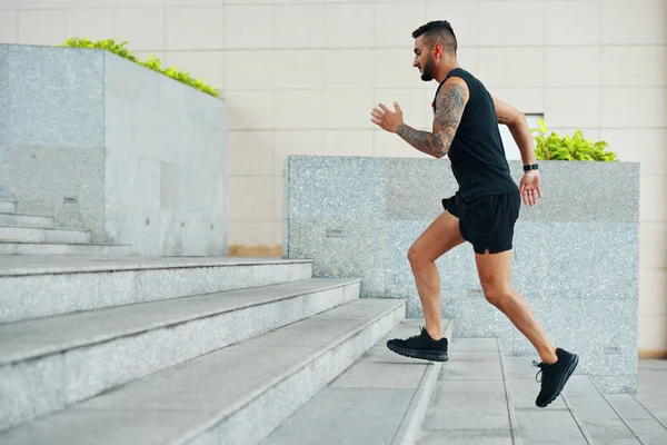 Zijaanzicht Van Mens Zwarte Sportkleding Lopend Trap Terwijl Het Buiten — Stockfoto